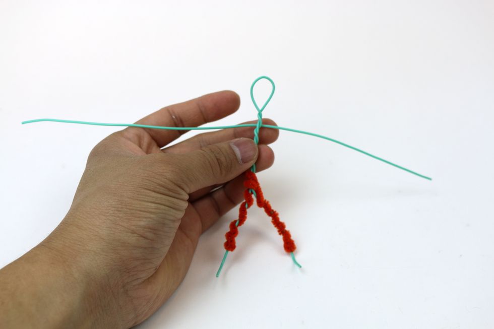 Get another wire and center it on the body. Remember that this wire will become the arms, so we want to line up the wire below the head.