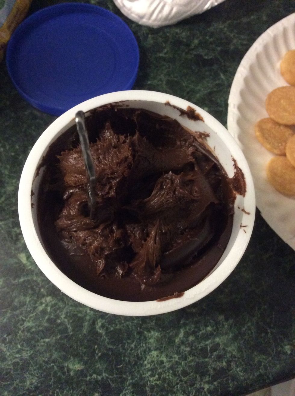 Get chocolate frosting and start adding to flat side of cookie