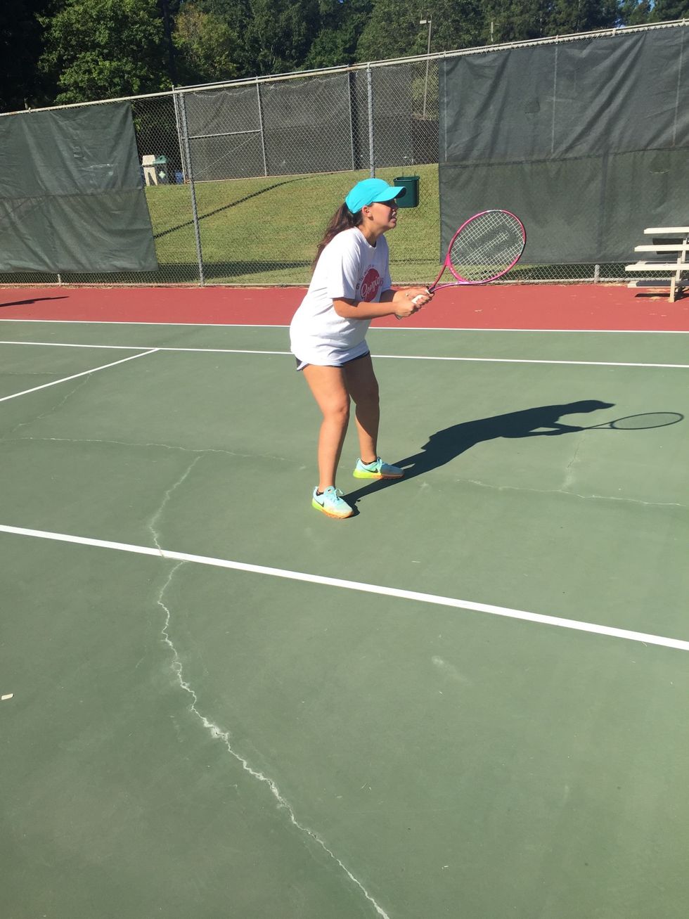 get into ready position. This means athletic stance, bending your knees slightly and having your racquet in front, so you are able to move quickly and react to wherever the ball will land.