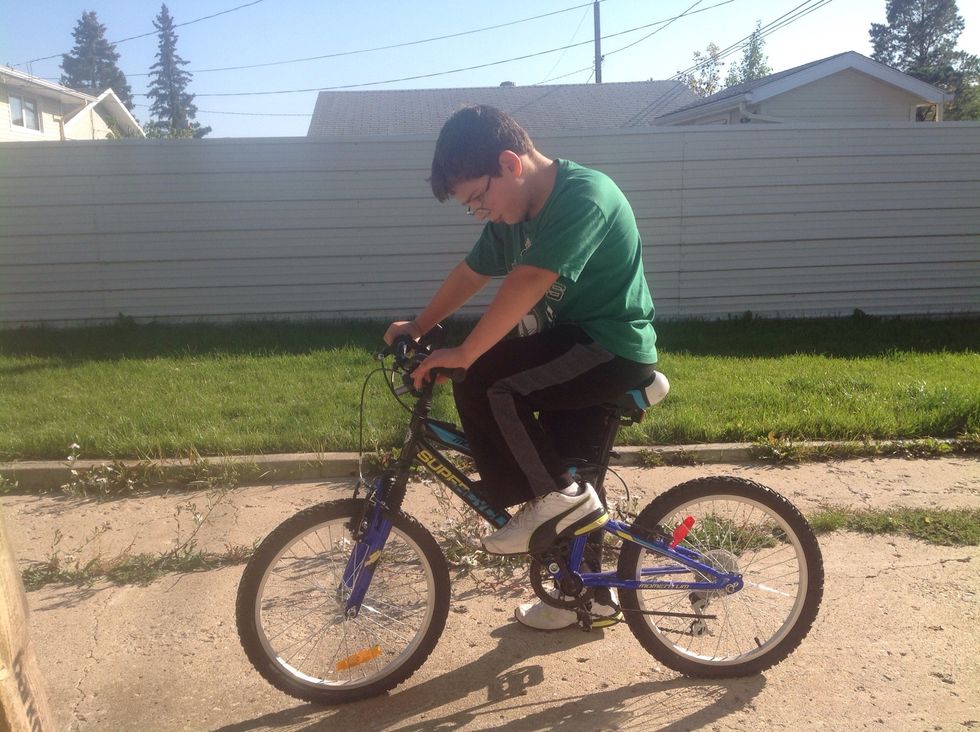 Get ready to go biking and have one foot on the pedal and one foot on the ground.