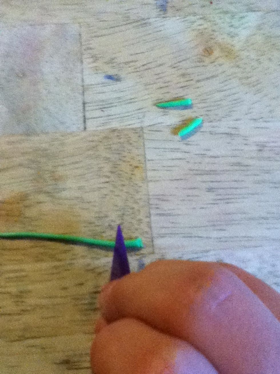 Get sharp thing (I'm using a clay tool) to cut three small green roll outs.