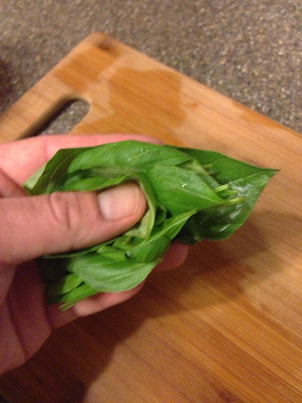 Get some basil leaves and roll them up. TIP: if you don't have one in your home or garden you can buy a small basil plant for ~$3 instead of spending slightly less for a small bag of clipped herbs.