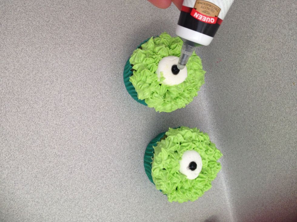 Get the black writing pen and make little circles in centre of marshmallow