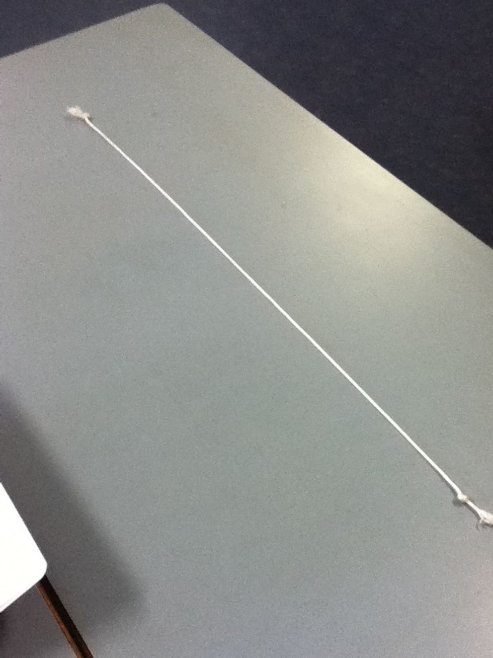 Get the piece of string and cut 70cm off it, tie at both ends of the string.