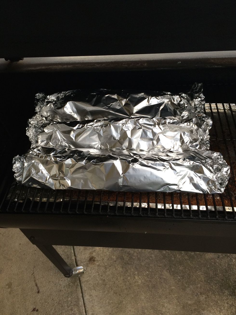 Get the three packages all snuggly. Be careful not to rip a hole in the foil or your liquid will leak out and your ribs will be a bit on the dry side. Double wrapping is ok, but I don't. 