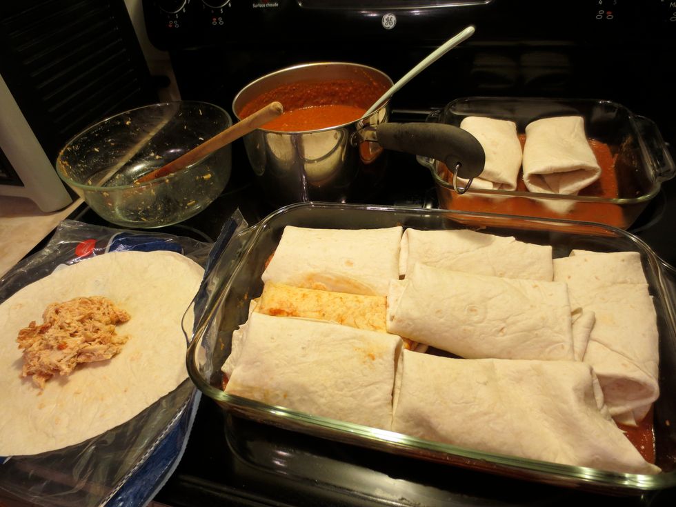 get the tortillas rolled up. They can be layered up on top of each other (sauce between layers) in one baking dish or in one single layer in a few dishes. I used 9"x13" and 9"x9" baking dishes