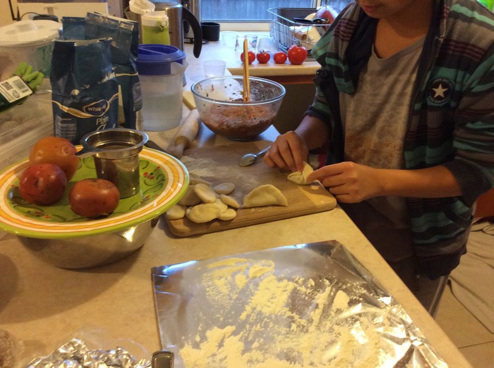Get the two tips of the flour and push them together. Then get the edge of the flour and push them out wards, then gently push them together.
