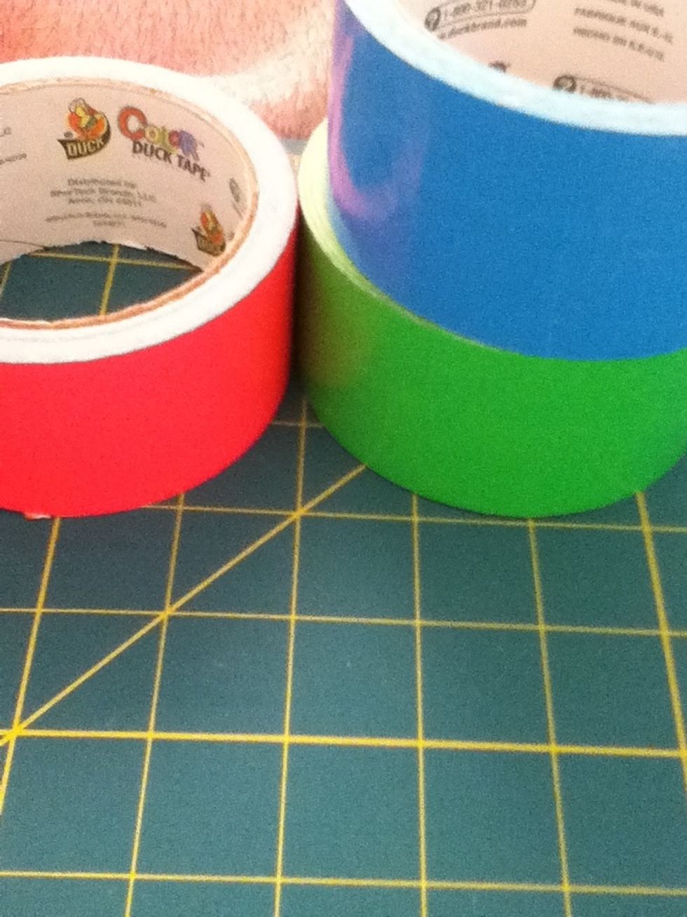 Get three colors of ductape.  Tow for the checkered patteren and one for the edges and the inside of the wallet. I am using blue and green for the patteren and pink for the inside.