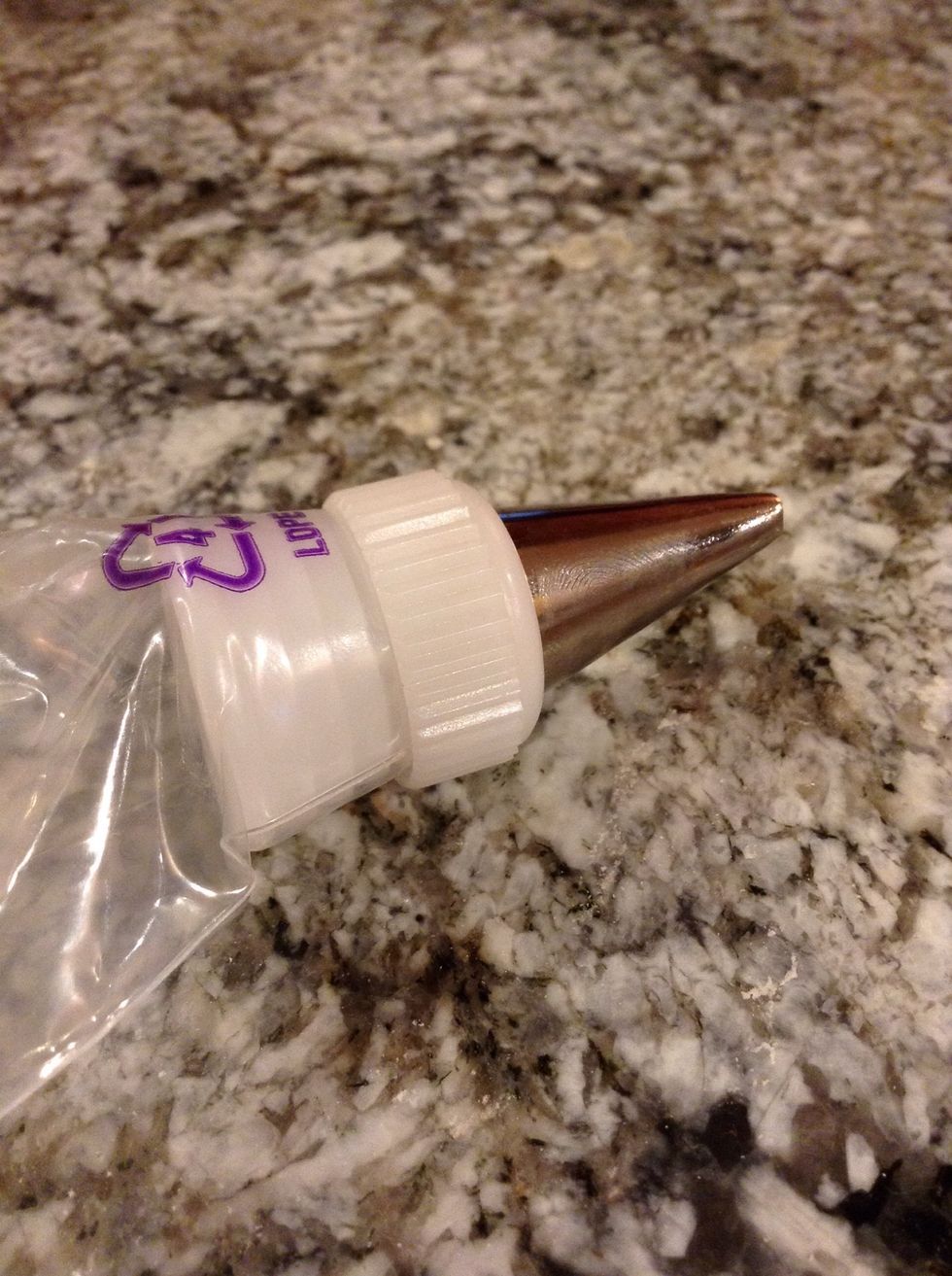 Get tip 104 and put it on the piping bag. Fold half the bag inside out to put in the frosting