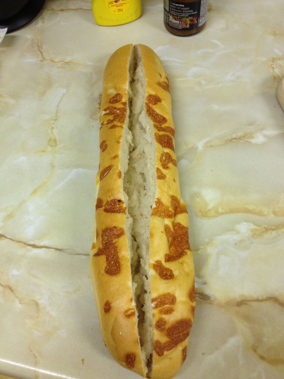 Get your baguette and slice it right down the middle, not all the way through your making it into a sub type sandwich. spread it out a little so it can take the fillings.. I used a cheese topped one