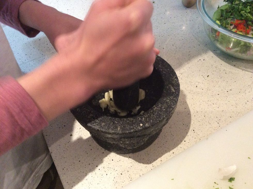 Get your clove of garlic and skin it then put it into the pestil and mortar and mash it up.