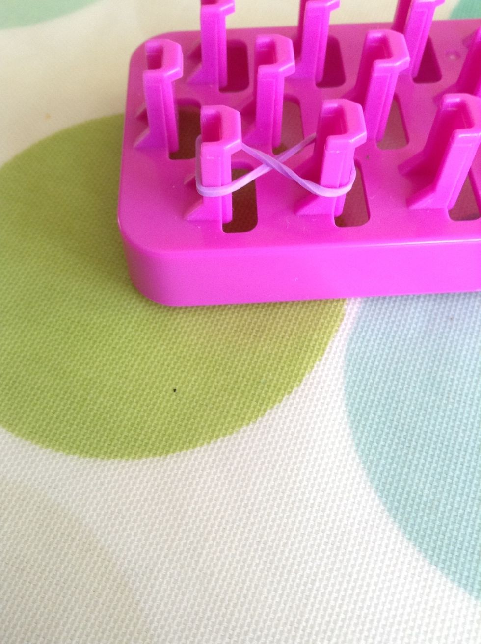 Get your fist band and make a figure of eight by twisting it once around two pegs.