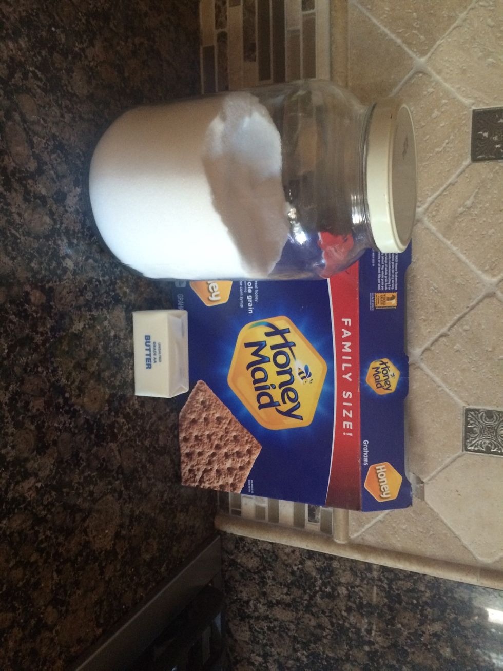 Get your graham crackers, sugar, and butter. As you can see my butter isn't melted, but your should be! * make sure to line your work surface with towels or something else to make for an easy cleanup