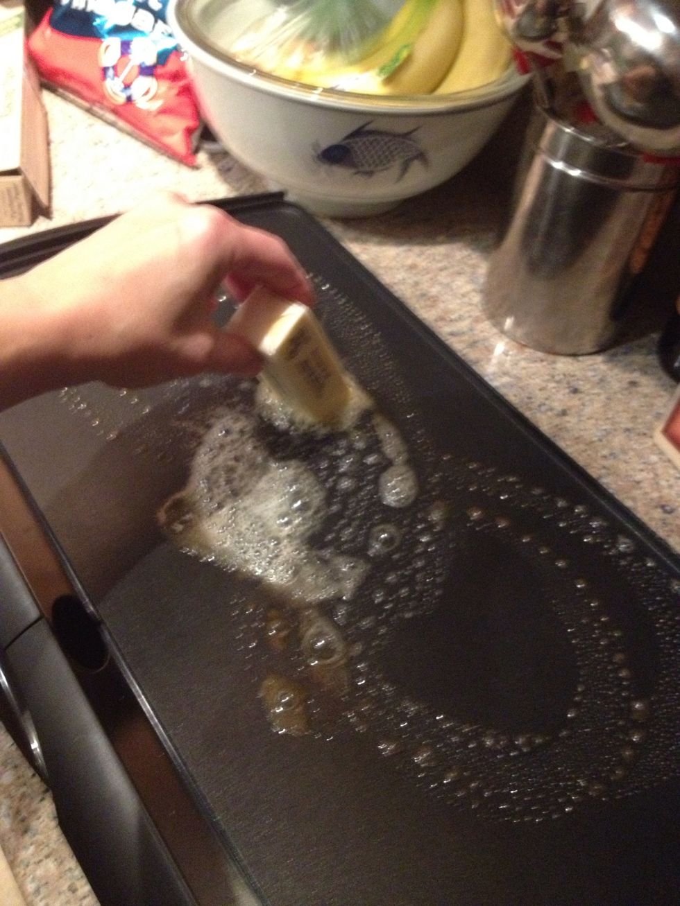 Get your griddle out, if you got one, or if you don't, you can use a fry pan and do one sandwich at a time. Take your stick of butter and slide it all around...