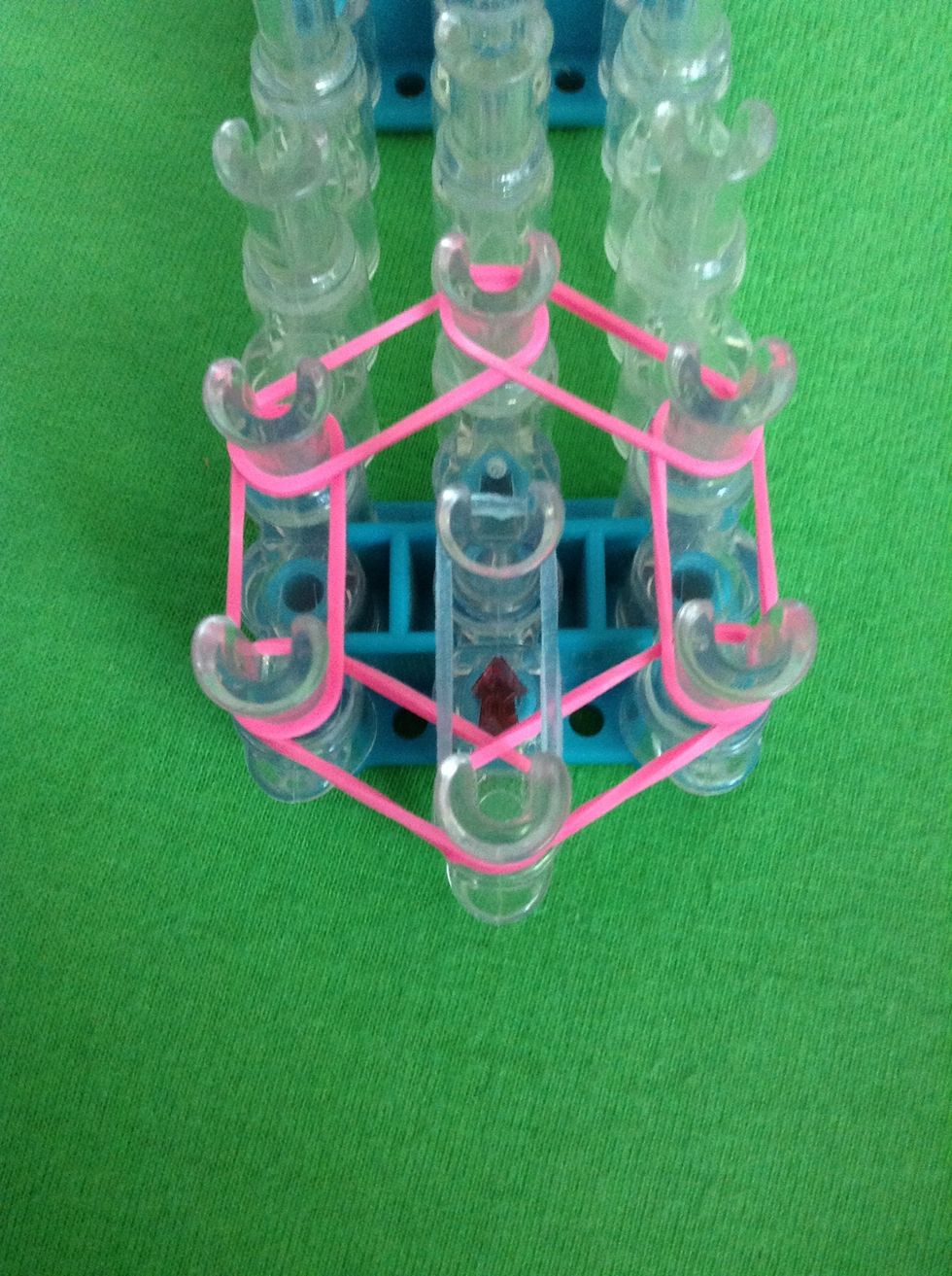 Get your next color of rubber bands and stretch it from the first peg to the center