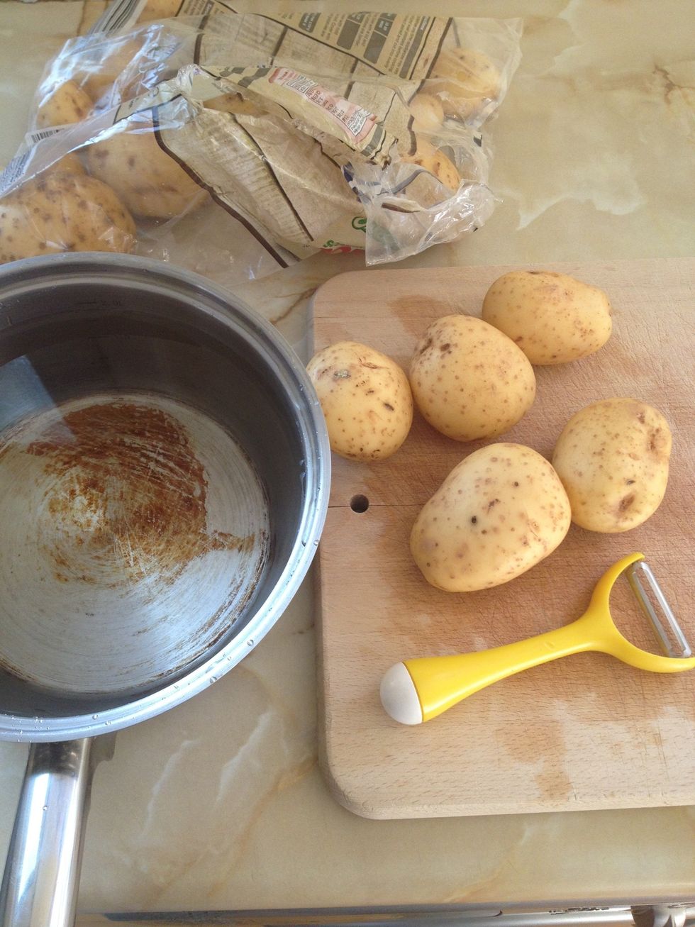 Get your potatoes, a peeler. A sharp knife will do if you don't have one, and a pot big enough for all the potatoes and fill it with cold water.