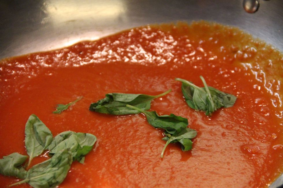 Get your tomato sauce in pan with a few leaves of basil