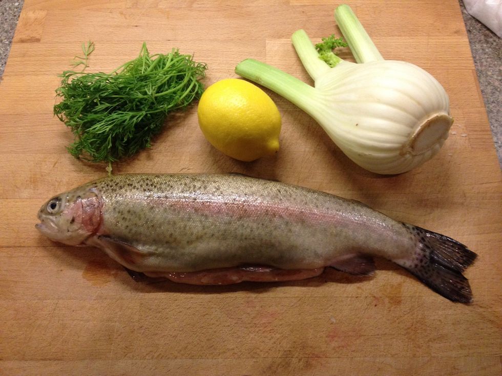 Get your trout that you have rinsed and dried and also the dill, lemon and fennel
