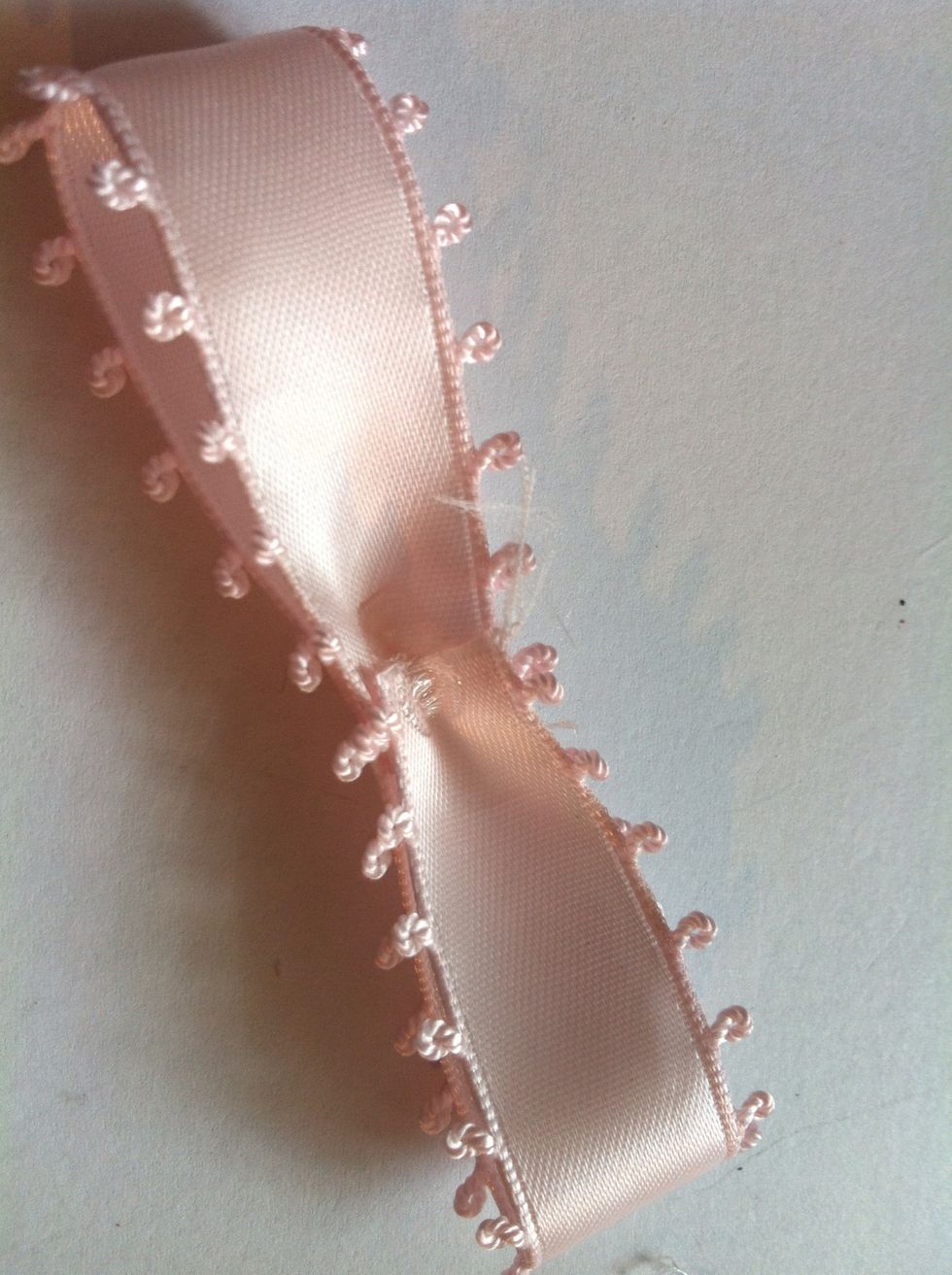 Glue a little bit in the middle. Before it drys, try to fold it inward like this, to create the shape of ribbon.