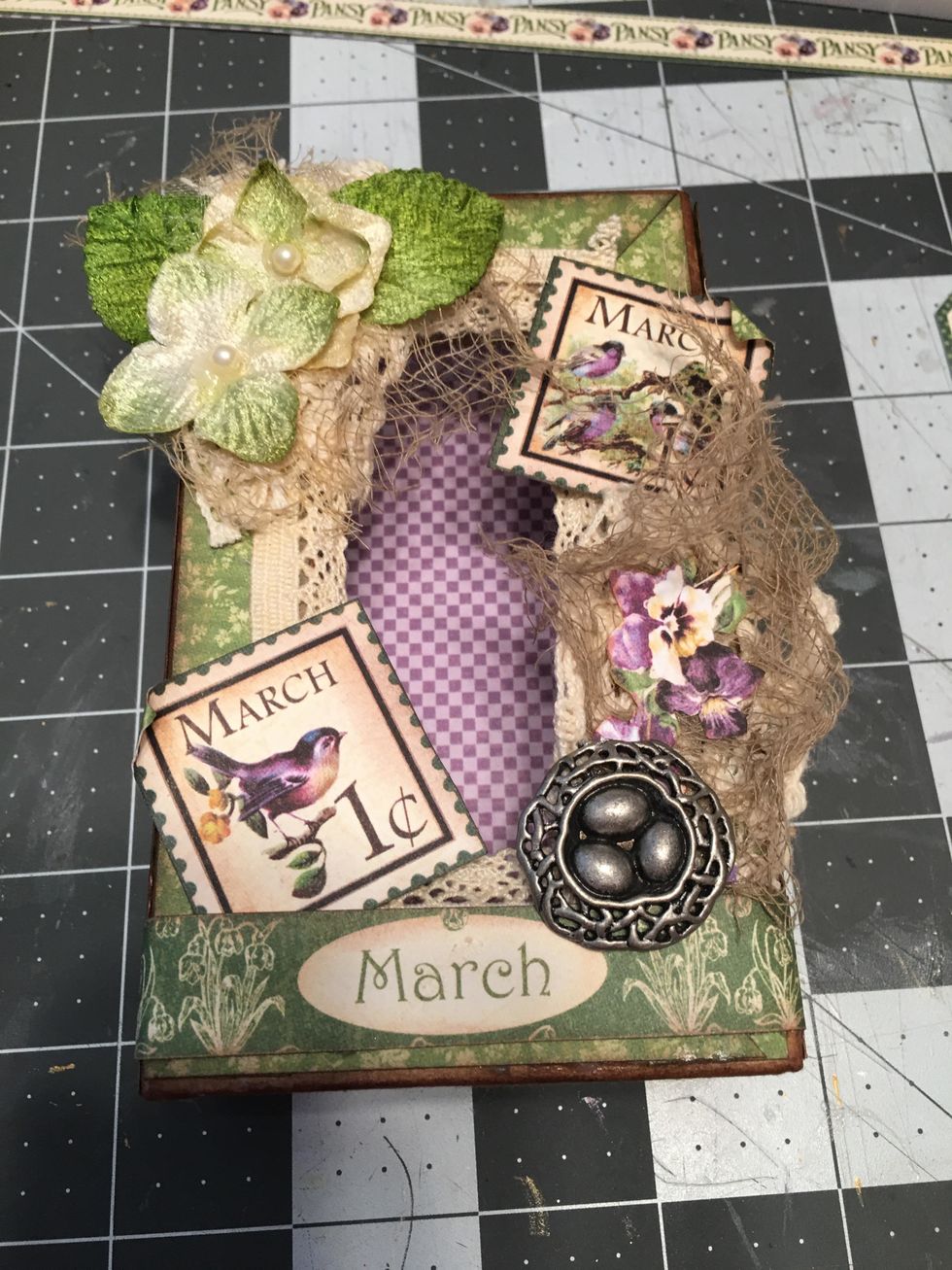 Glue a metal bird nest charm to the right side and another stamp on the upper right side.