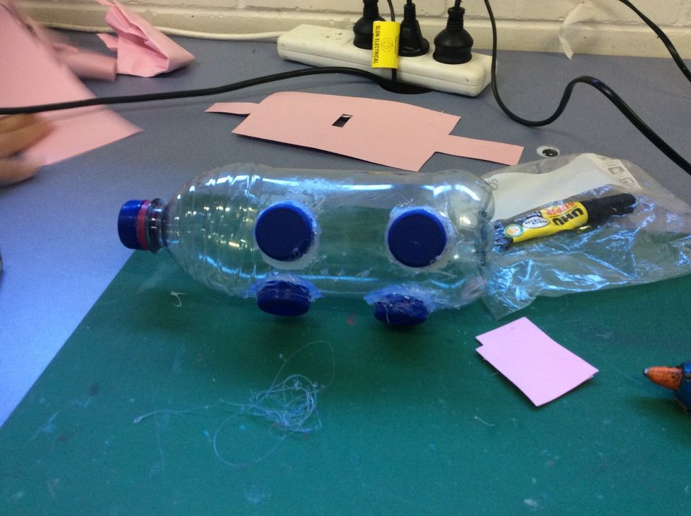 Glue all your blue bottle caps on the bottom of your bottle to make legs