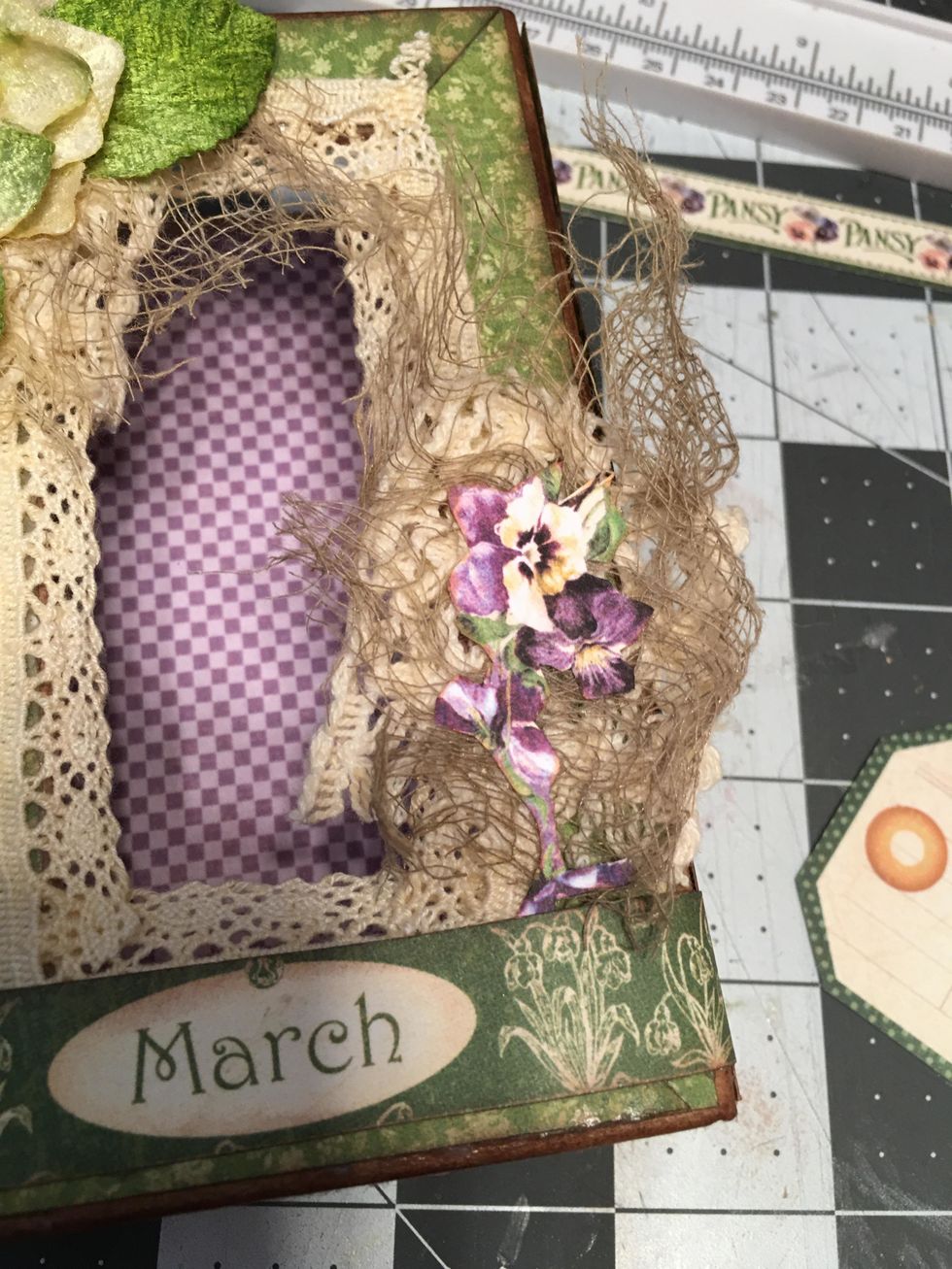 Glue another piece of the wide crochet lace to the right side of the lid and another piece of gauze. Fussy cut out some paper flowers and glue into place.