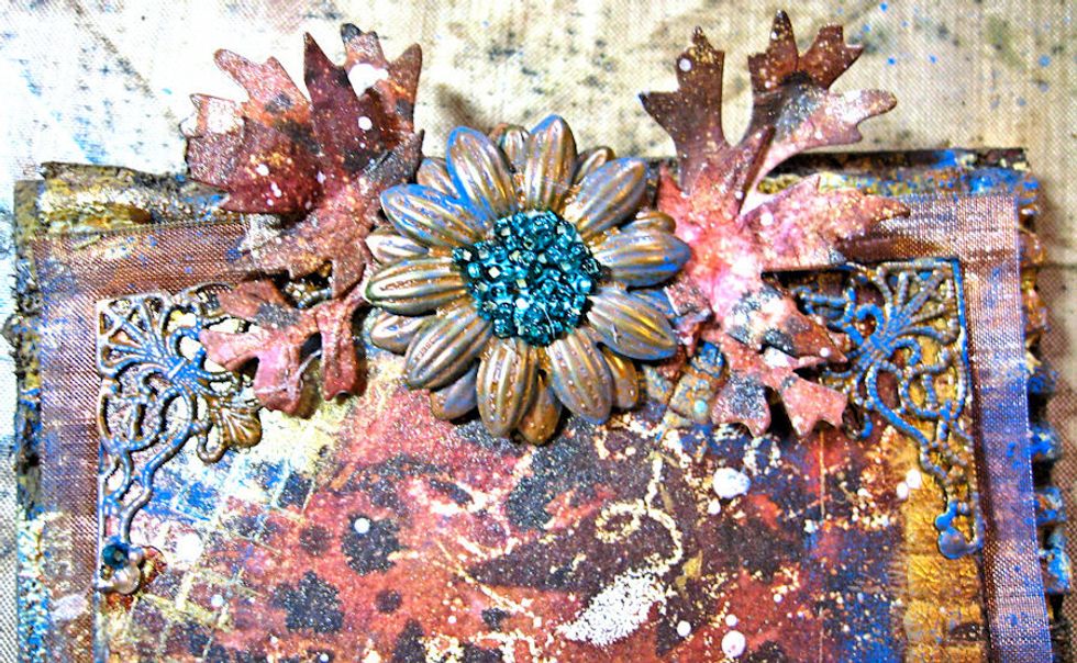 Glue filigree metal corners on both sides  at the top of the 4" x 6" panel. Add leaves.  Layer 2 flowers together staggering petals and glue in place between leaves.  Add glue and beads to center.