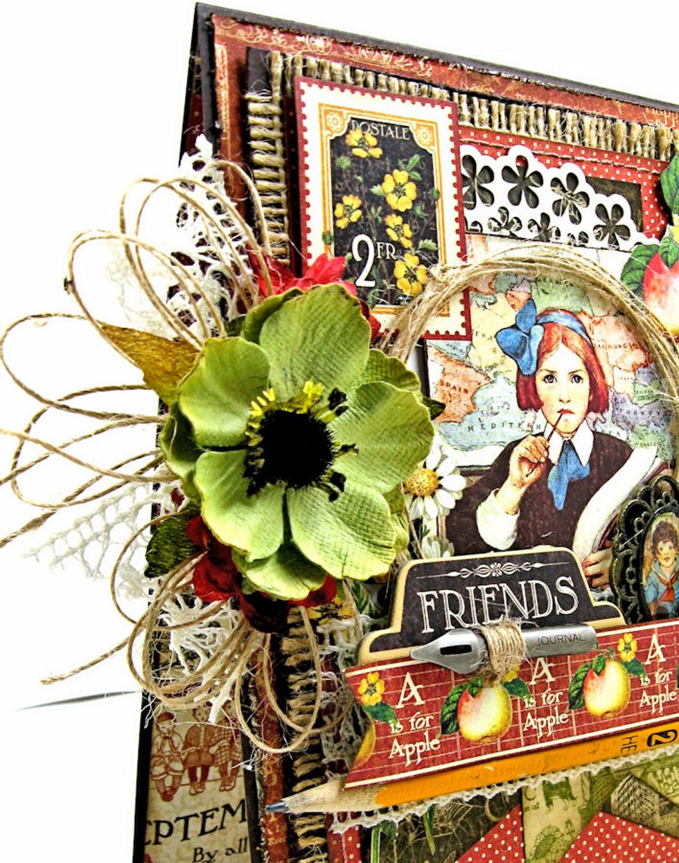 Glue green Petaloo Anemone on top of ribbon cluster. Tuck a small red Botanical mini on either side of the larger flower and glue in place. The front of the card is now finished!