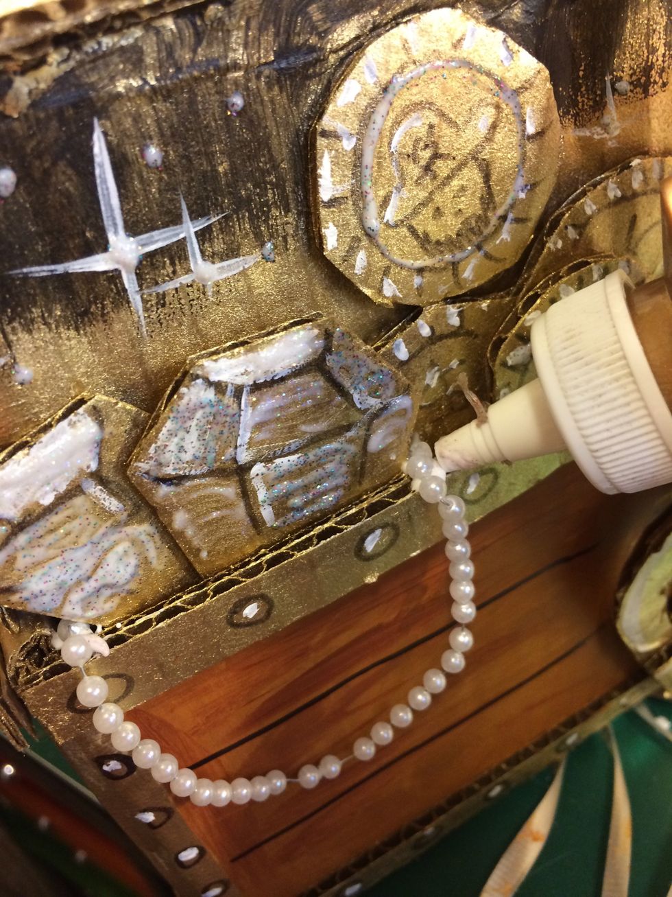 Glue on some fake pearl necklaces that hang out of the box!