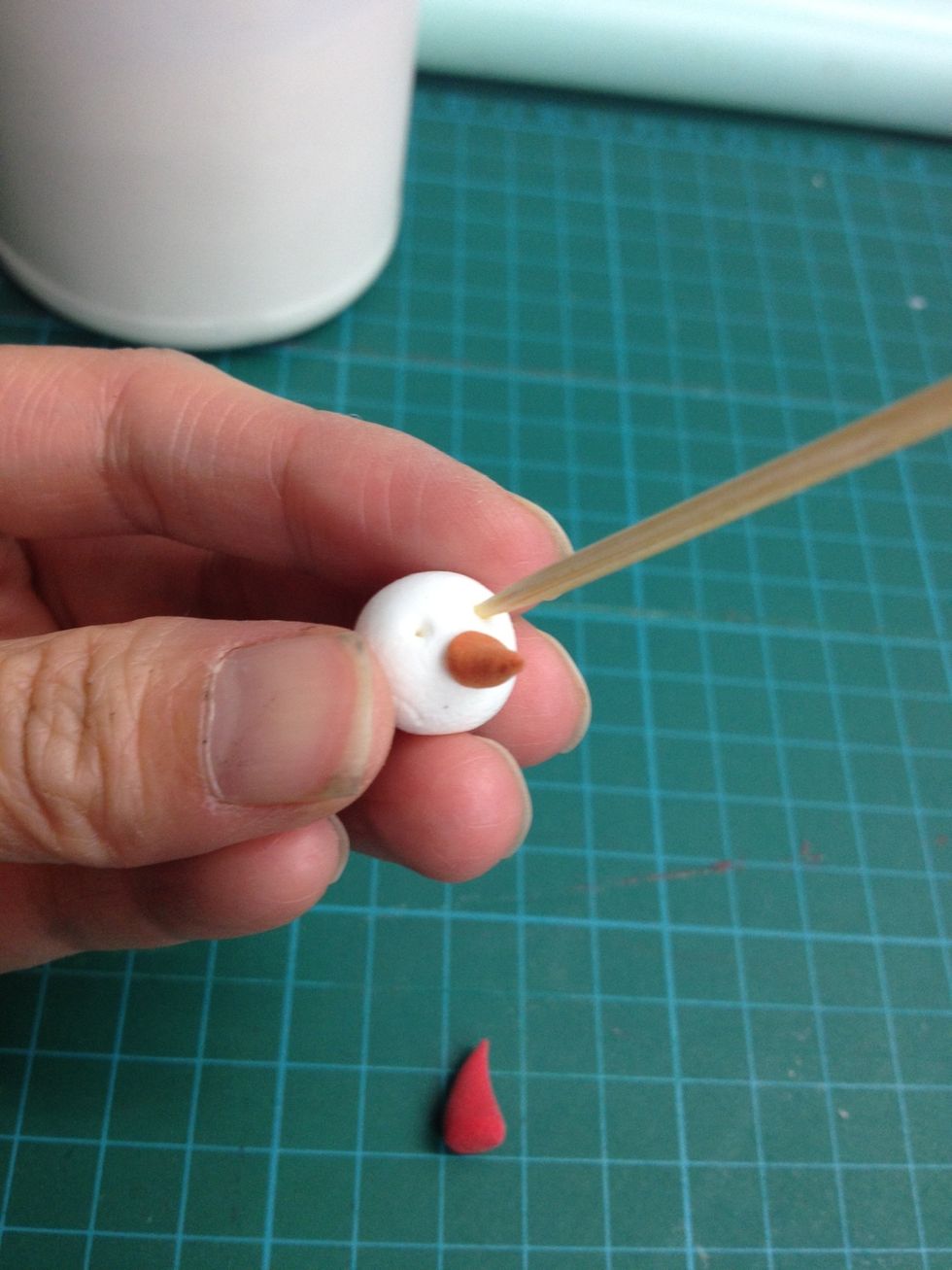 Glue on the nose and then pin 2 holes as the eye.
