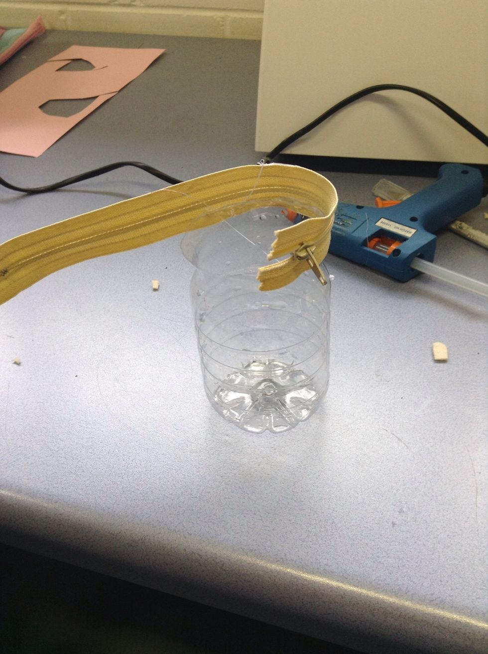 Glue one half of the zipper onto one of the plastic bottles