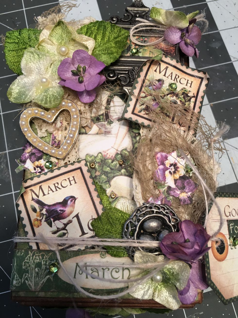 Glue other decorative bits to the front of your lid such as the white pearl heart charm, small green rhinestones and gold seed beads.