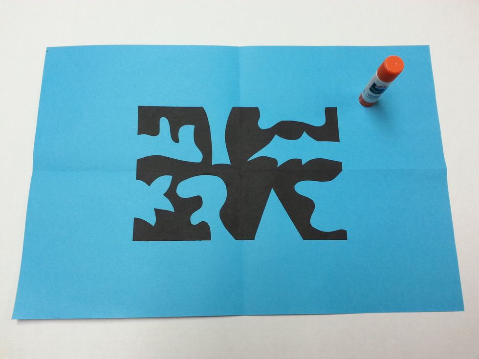 Glue the black rectangle onto the colored paper.