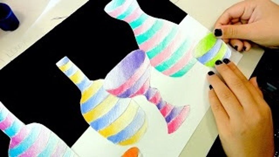 Glue the bottle shapes down to the white area of the per. Pay attention to what shapes are in front and what is farther back. Try to show depth with overlapping shapes and the size of the shapes.