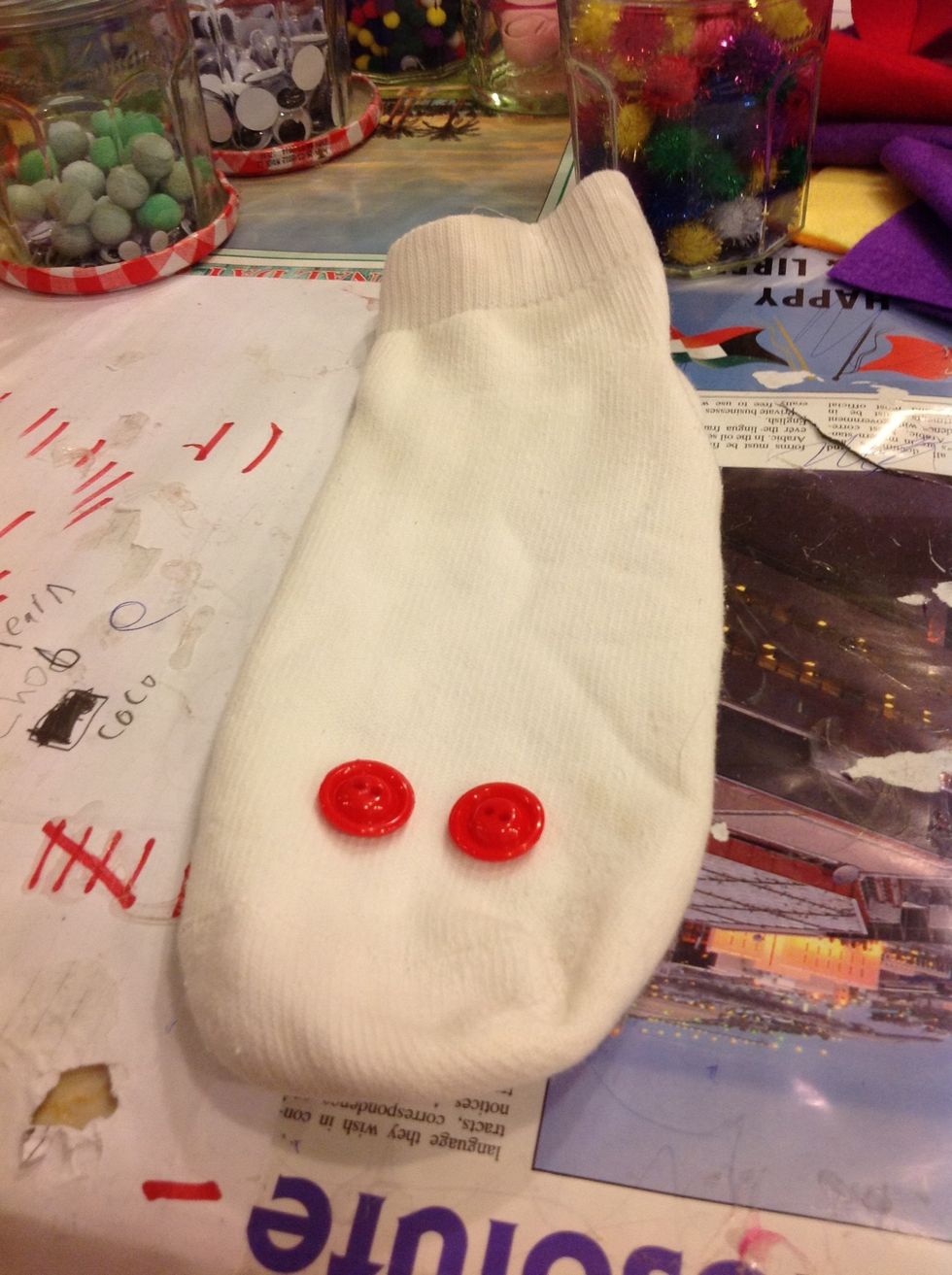 Glue the buttons to the sock with your glue gun ( or you can sew it)