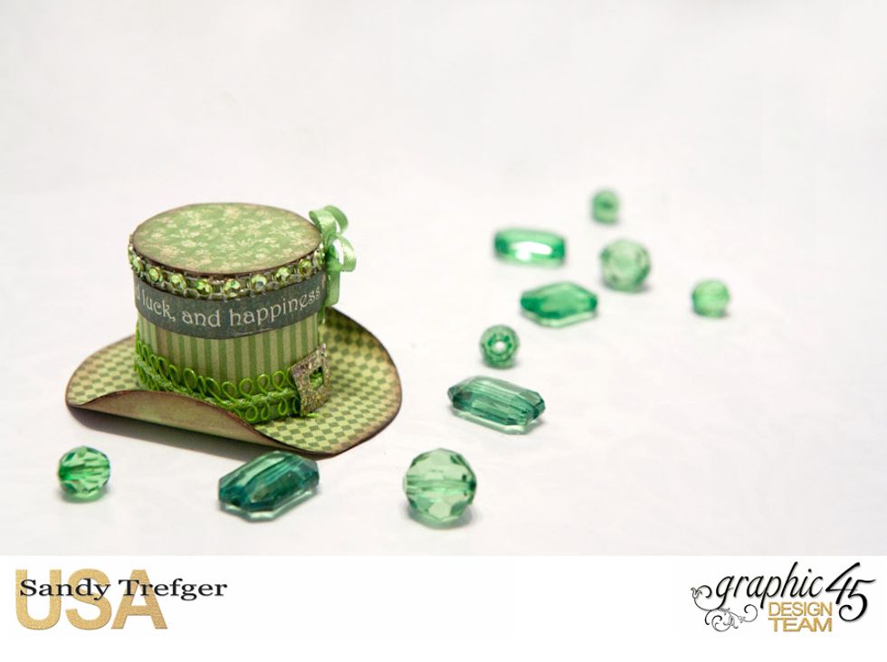 Glue the cylinder to the brim and glue the top to the cylinder. add trim, ribbon, bow and create a small buckle with scor-tape and fine glitter as shown. Ink all edges and curl up the brim a bit.