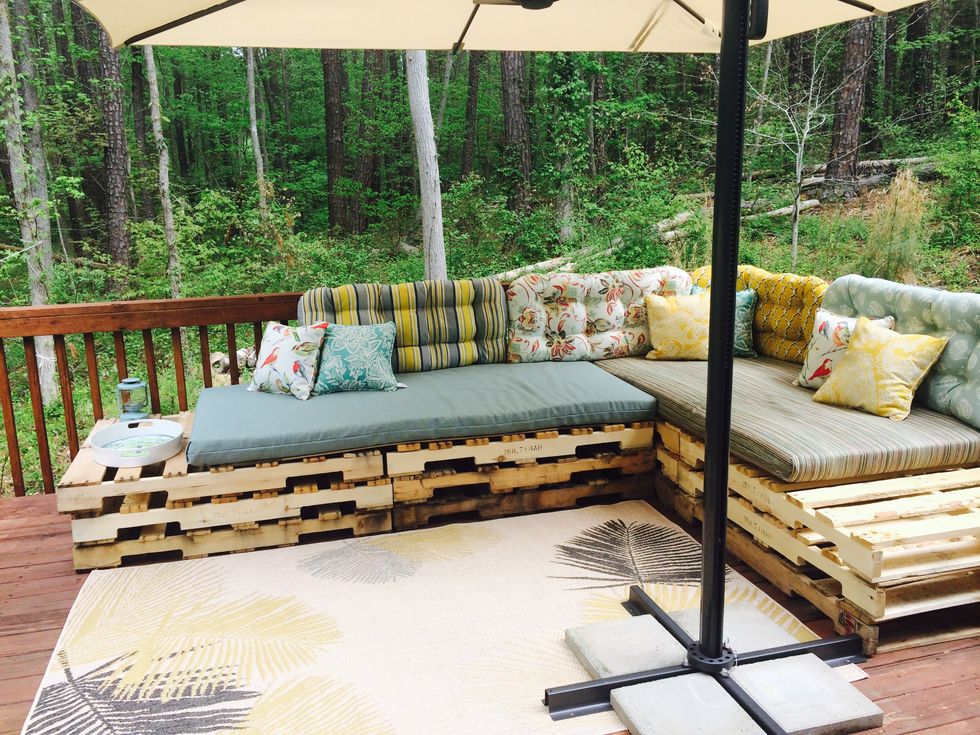Glue the open end of your mattress cover with fabric glue. Spray the covers with water resistant spray to keep the moisture out. Purchase an outdoor rug, umbrella and some coffee tables