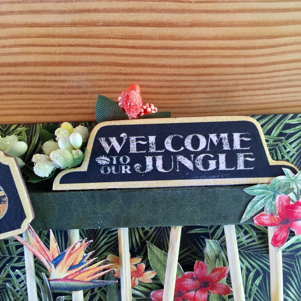 Glue the other chipboard on the top of the cage and add more paper flowers.