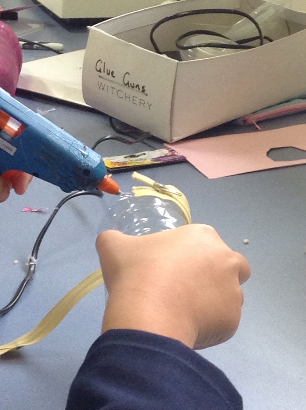 Glue the other half of the zipper onto the other plastic bottle