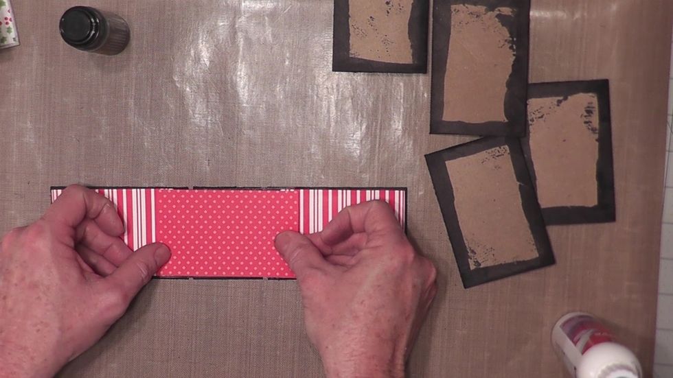 Glue the paper to the front and back covers first. Then center & glue the paper over the spine as shown.