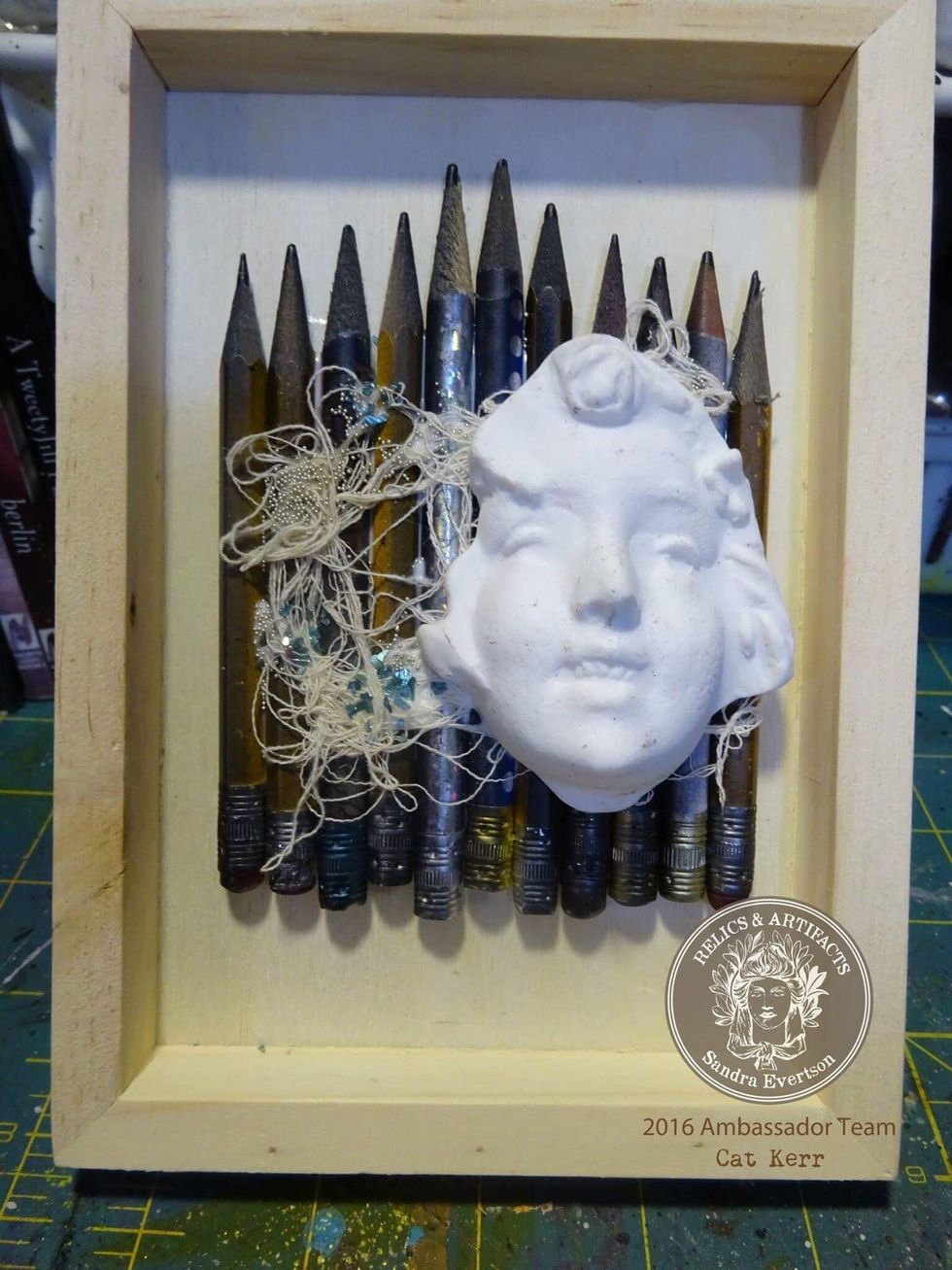 Glue the pencils,string,micro beads and relic into the wooden tray case