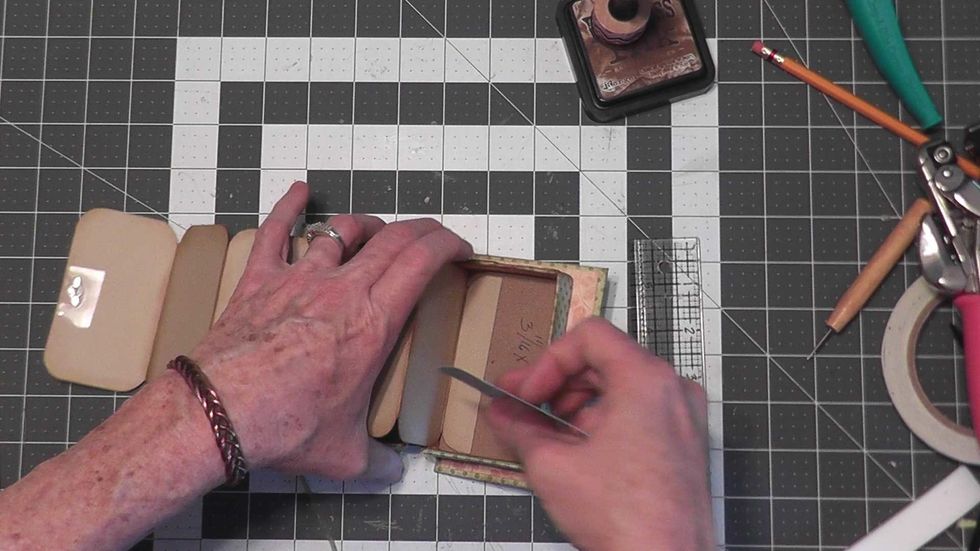 Glue the remaining 3 7/8" tall x 2 1/4" wide paper into the right side of the box covering the short tab that holds the pages into the album.