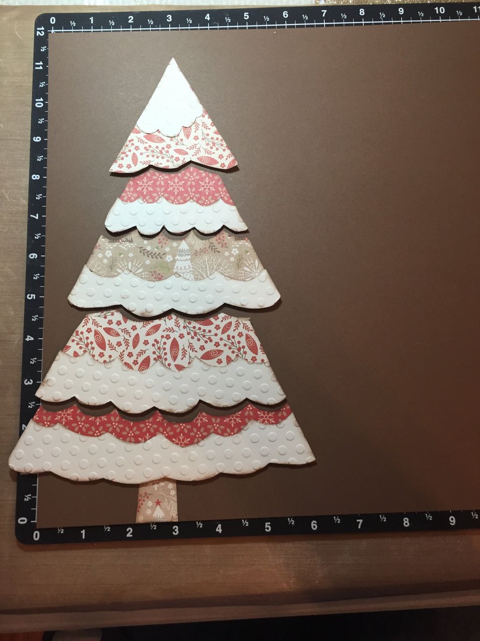 Glue the snow pieces onto each of the Christmas tree sections. Set the Christmas Tree on a 12 x 12 Chocolate Cardstock to get spacing before you attach to base. Leave 1/8" spacing.