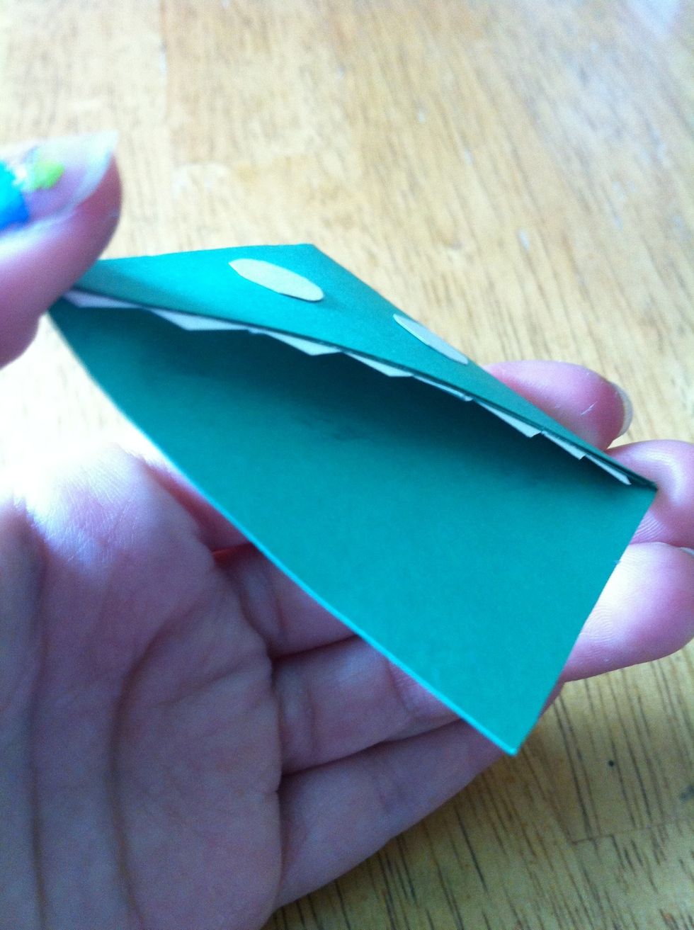 Glue the teeth to the top of the inside. Do not glue the teeth to the bottom, for the page will be going in. Also glue on the eyes.