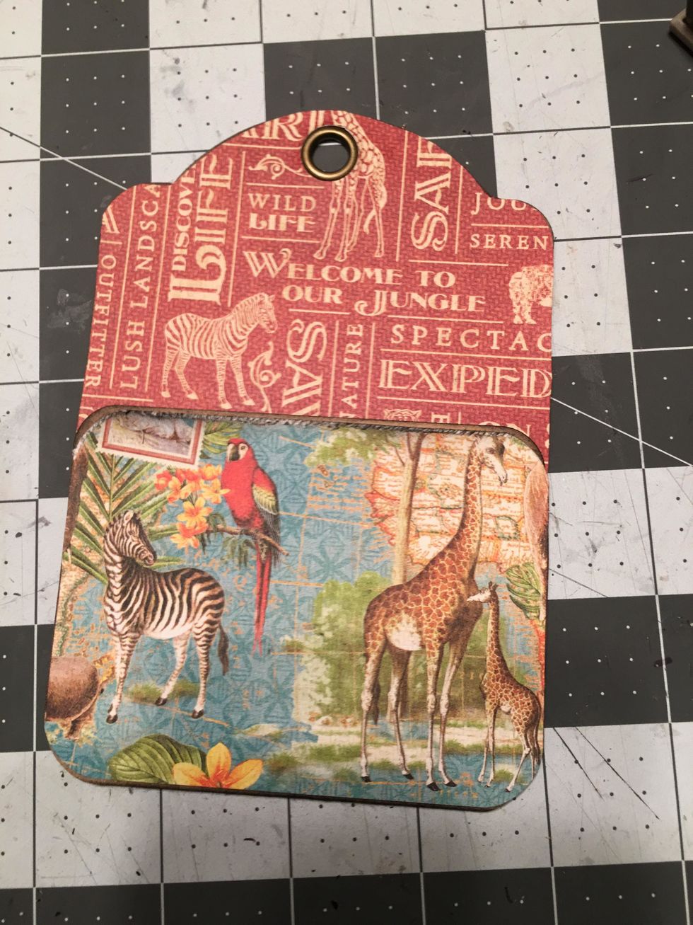 Glue to the top half of the tag, lining it up so that the hole fits over the grommet.