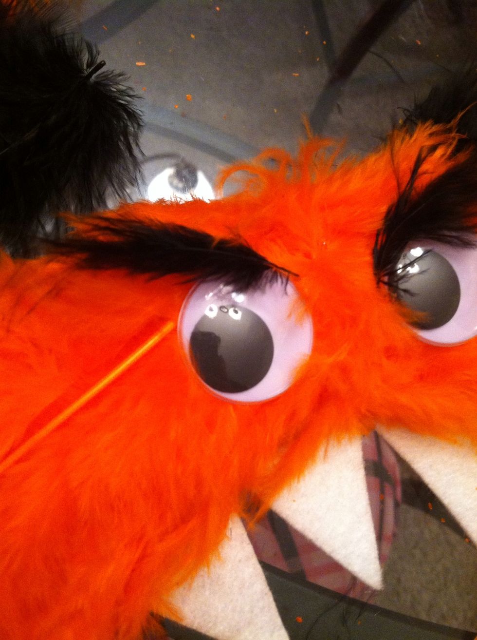 Glue two small black feathers above the eyes as eyebrows.