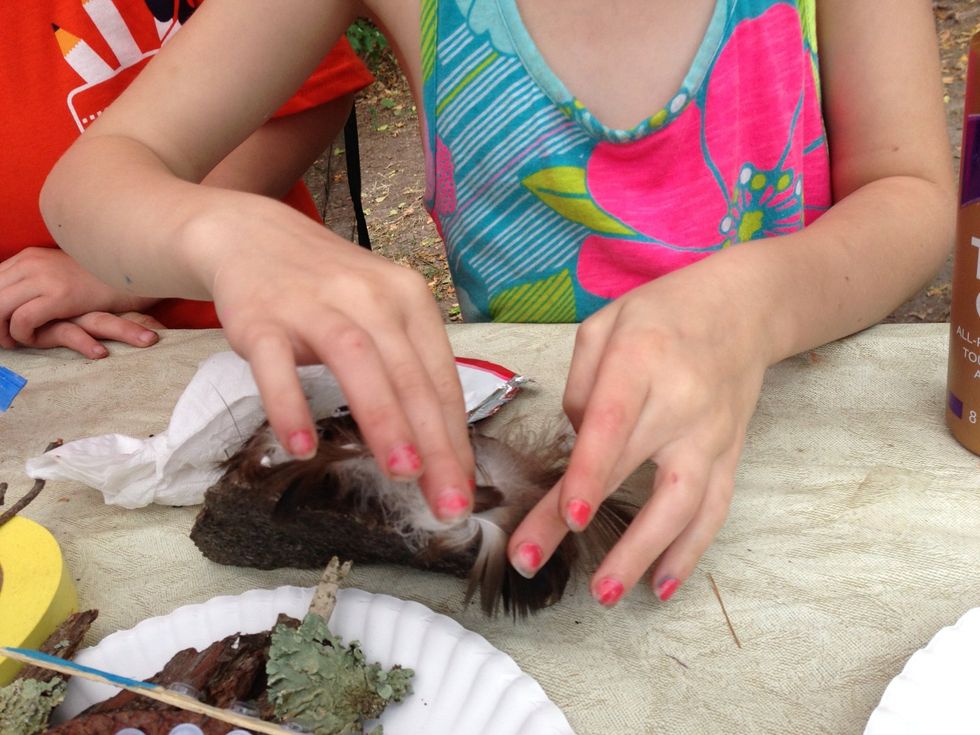 Gluing feathers for hair.