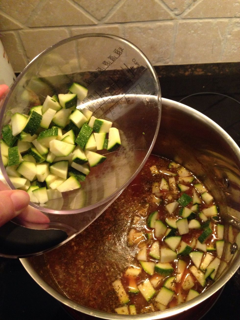 Go ahead drop your zucchini and then green beans into the pot.