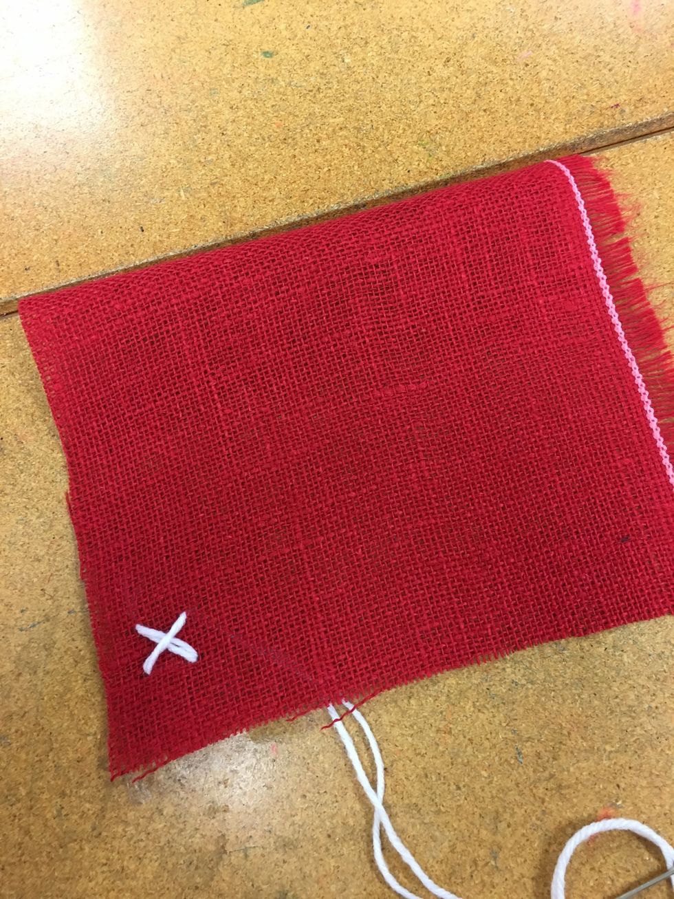 Go down in the opposite diagonal corner.  Pull your yarn all the way through and you should have an X.