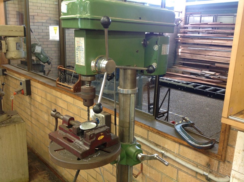 Go over to the drill press and where you marked the hole with the centre punch line that up with the drill bit. Slowly drill a hole through your circle.